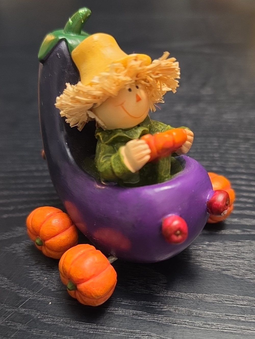 Autumn figurine of a scarecrow in a Eggplant cart